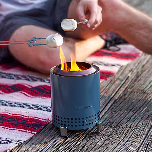 Blue tabletop fire bowl with a lit flame.